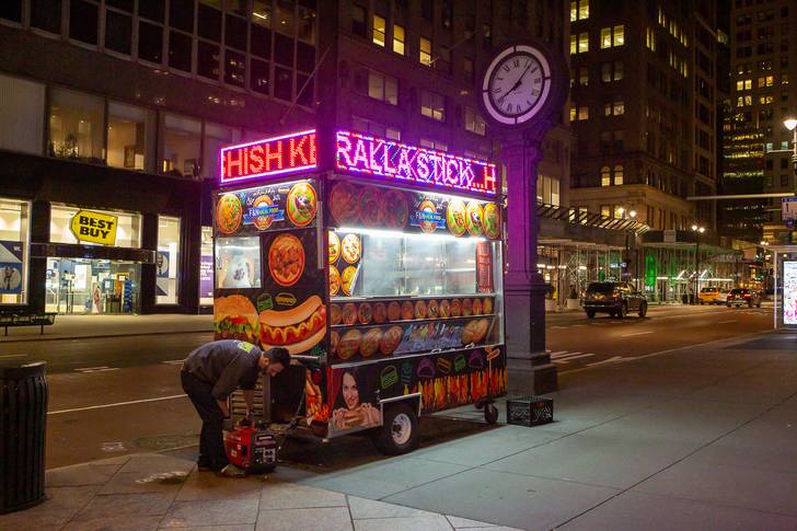 A photograph of a halal cart with a worker nearby.